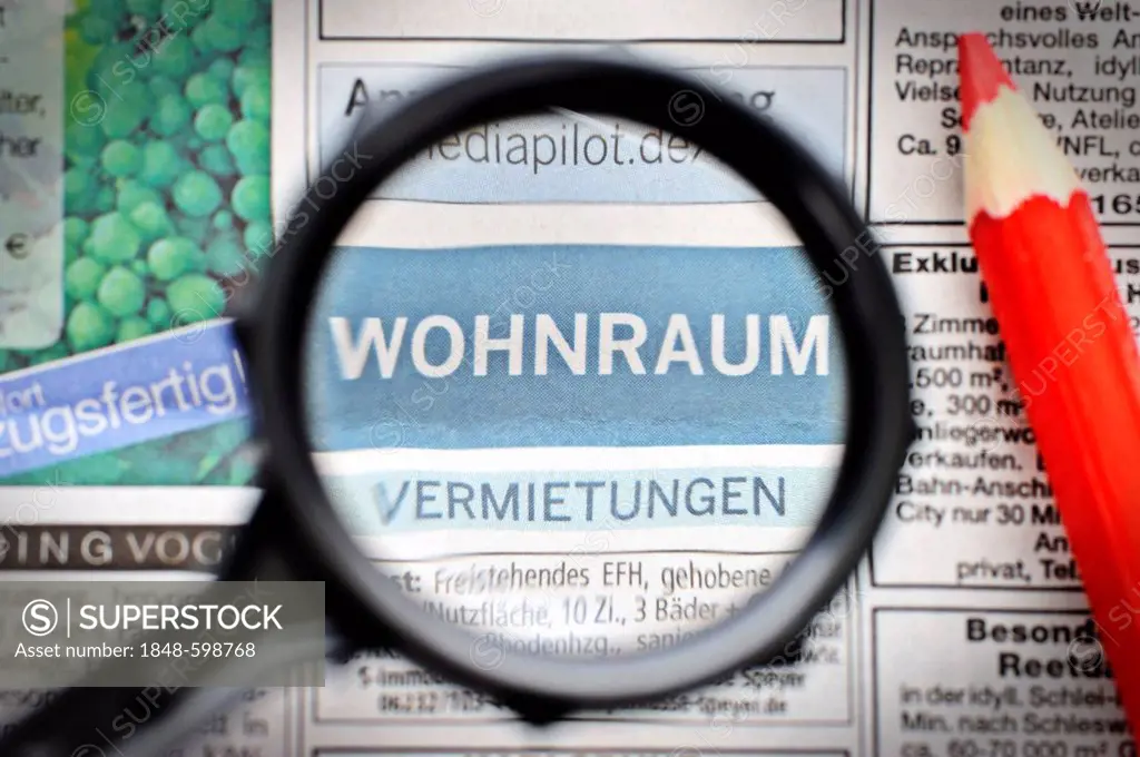 German apartment listings, housing advertisements viewed with a magnifying glass, housing shortage