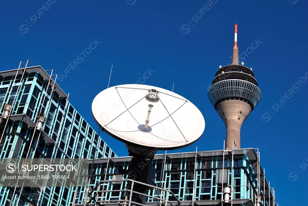 TV satellite transmission system in front of the building of the WDR local tv studio, behind the Rheinturm radio and tv tower, Duesseldorf, North Rhin...