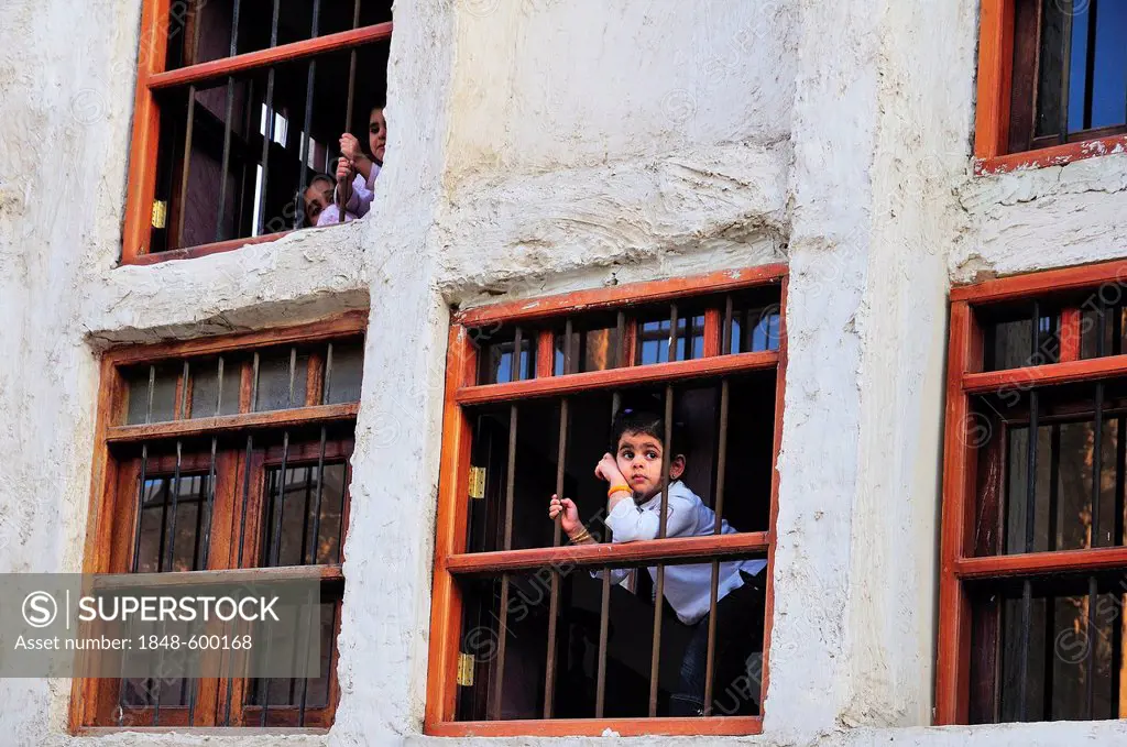 Children looking through barred windows, Doha, Qatar, Middle East