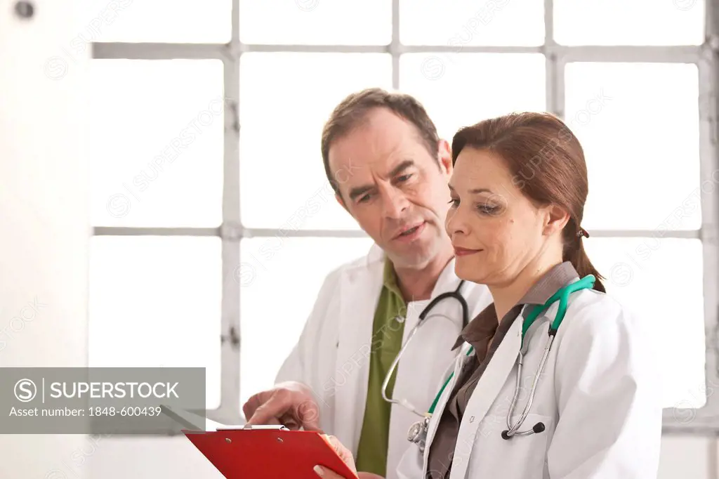 Doctor and a female doctor discussing patient records