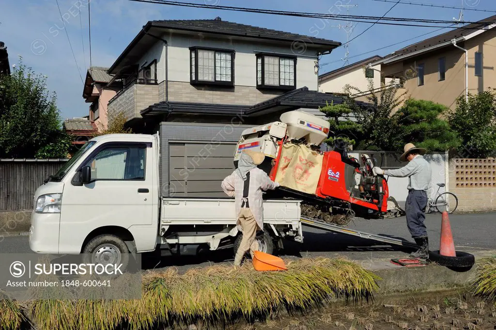 Rice farmer loading his combine harvester on a small truck, Iwakura near Kyoto, Japan, Asia