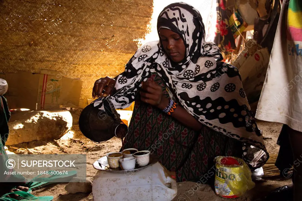Young Afar woman serving traditional Ethiopian coffee, village of Hamed Ale, Danakil Depression, Ethiopia, Africa