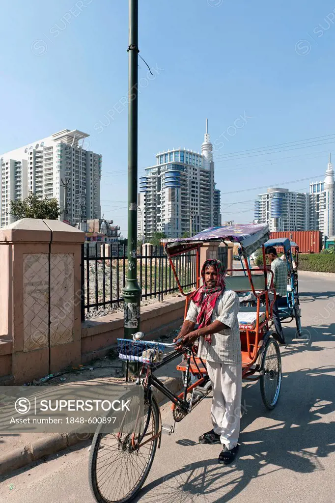 Rickshaw drivers in front of new residential high-rise buildings in Gurgaon, Haryana, India, Asia