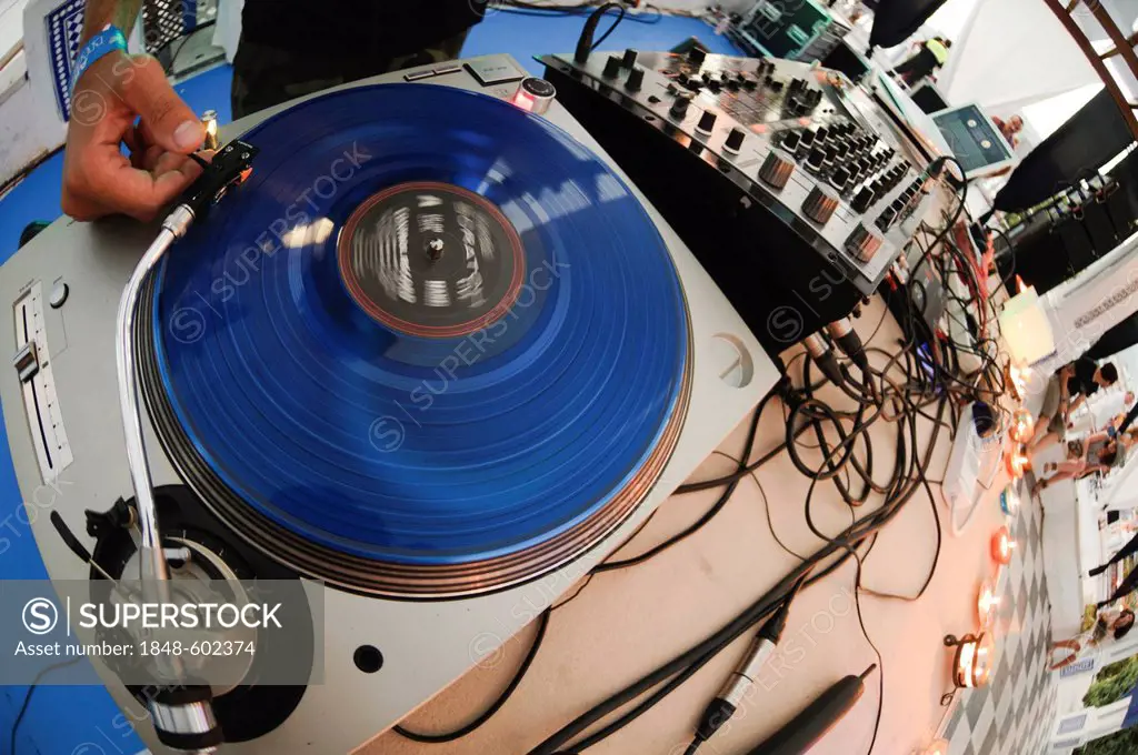 DJ using a blue scratch disc on a turntable during the Electrobeach Festival at Benidorm, Spain, Europe