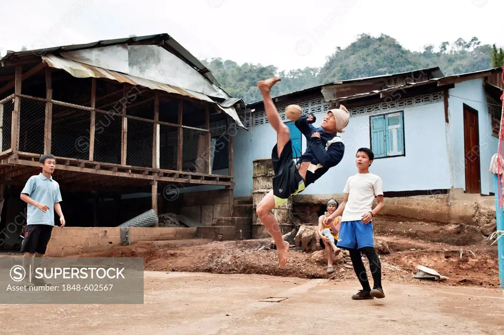 Teenage boys playing a game of Sepak takraw in the Mae La refugee camp, Tak province, Thailand, Asia
