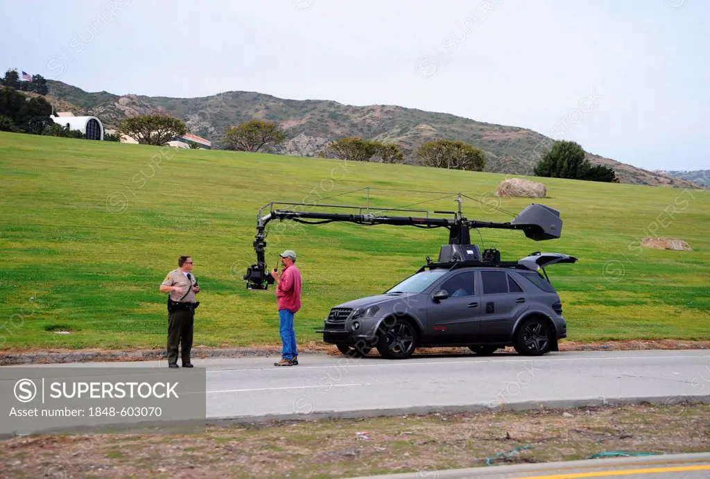 A Mercedes ML with outside camera films driving scenes, employee of a film crew and a U.S. police near Malibu, California, USA, America
