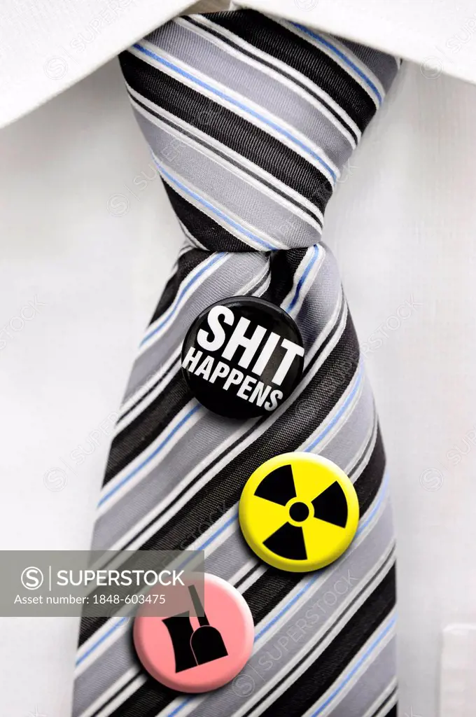 Tie with badges, symbols of radioactivity, a nuclear power plant and the message Shit happens
