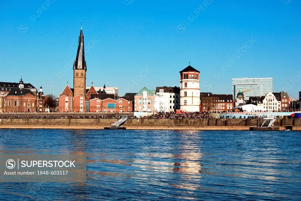 View across the Rhine River to the Basilica of St. Lambertus and Schlossturm tower, headquarters of the Schifffahrtsmuseum or Maritime Museum on the b...