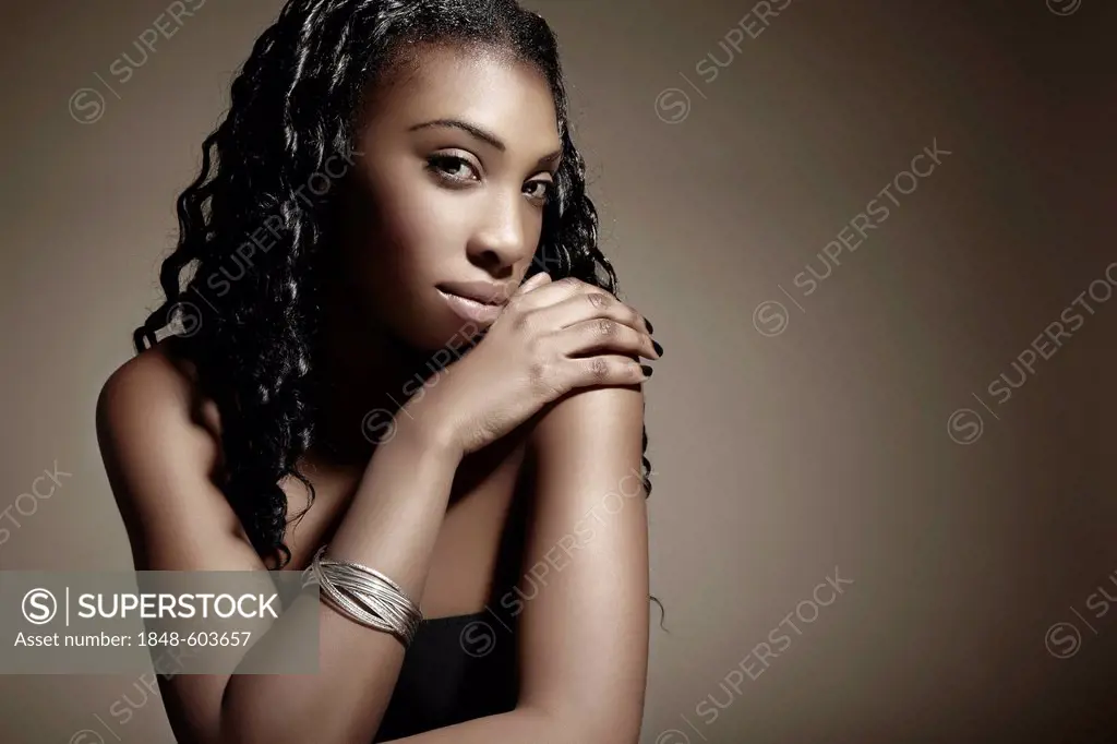 Portrait of a young dark-skinned woman wearing silver jewellery, beauty shot