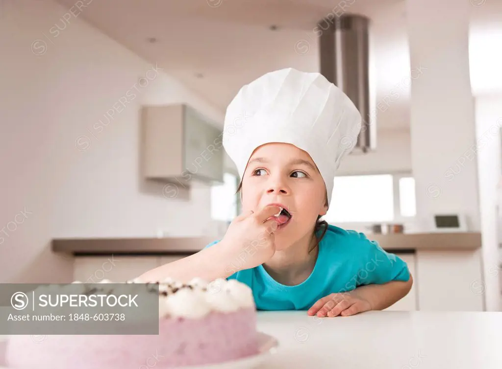 Little girl with chef's hat nibbling from a creampie