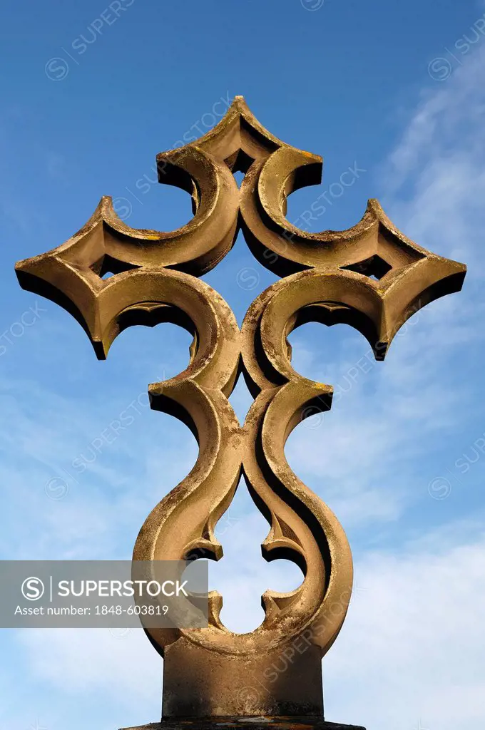 Unusually designed stone cross on a grave, 19th Century, against a blue sky in the cemetery of Guebwiller, Route de Colmar, Guebwiller, Alsace, France...
