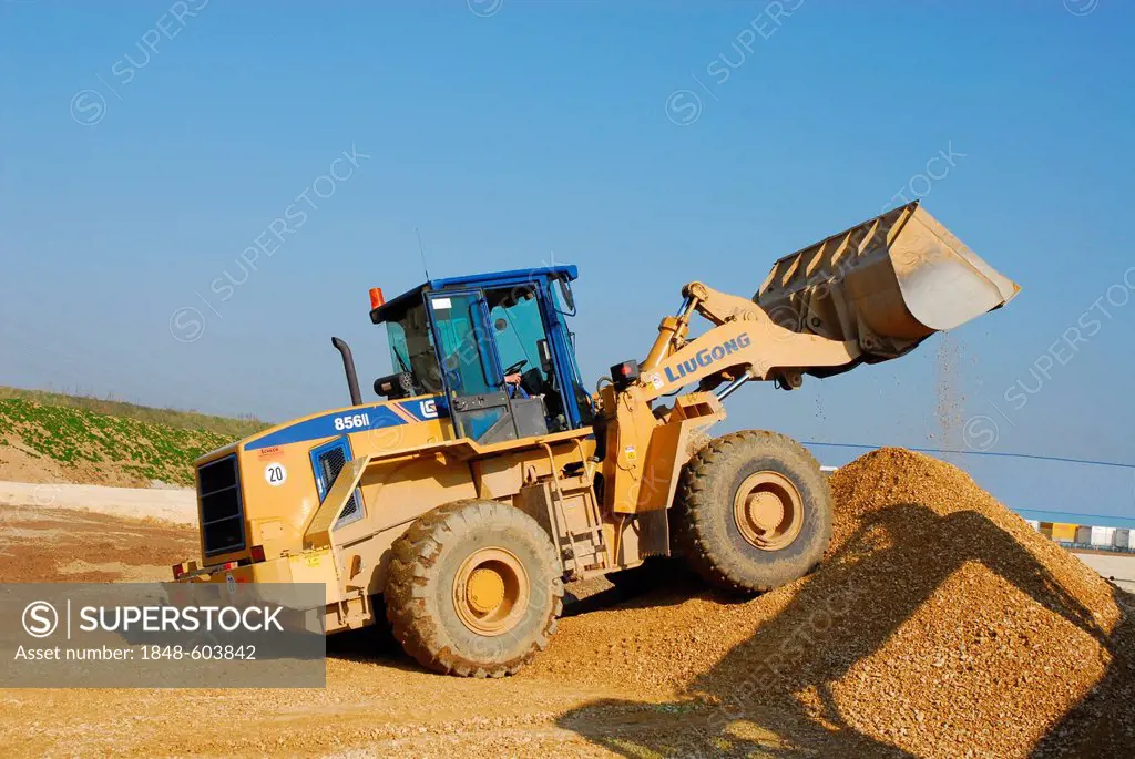 Wheel loader at a construction site rearranging gravel, crushed stone and antifreeze