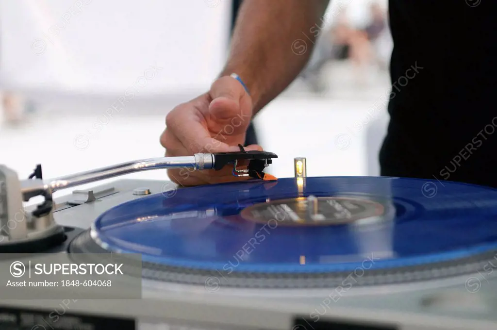 DJ using a blue scratch disc on a turntable during the Electrobeach Festival at Benidorm, Spain, Europe