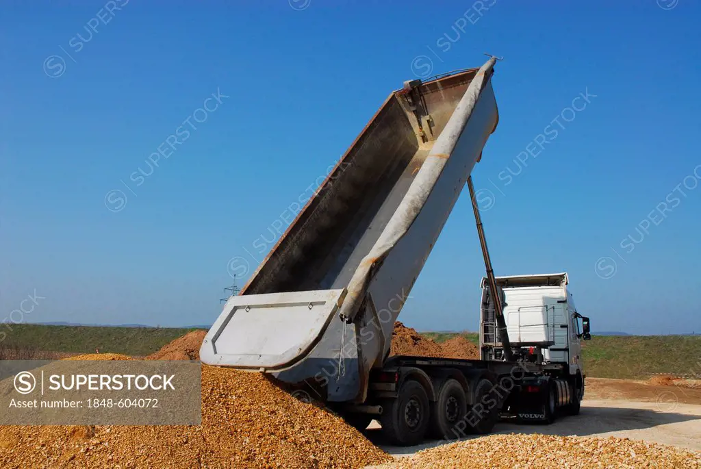Dump truck or earth moving truck delivering sand to a large construction site