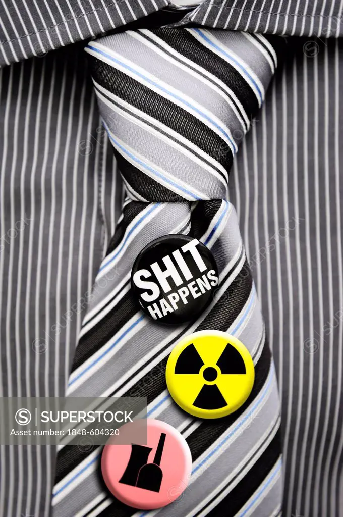 Tie with badges, symbols of radioactivity, a nuclear power plant and the message Shit happens