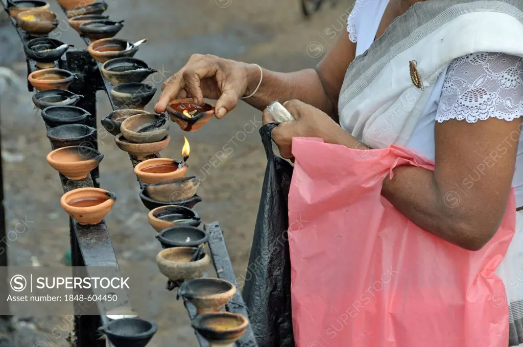 Woman lighting butter lamps, Puja, Ruvanveli Seya Dagoba or Ruwanweliseya Dagoba, Anuradhapura, Unesco World Heritage Site, Sri Lanka, Ceylon, South A...