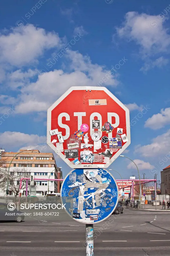 Stop sign defaced with stickers, and direction arrow, Berlin, Germany, Europe