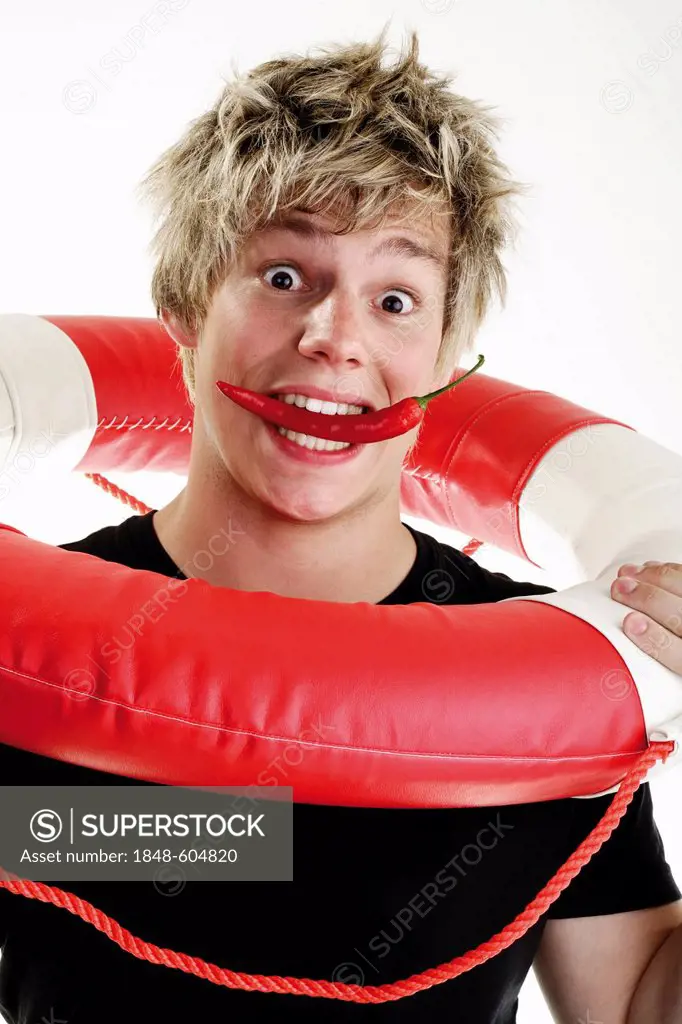 Young man with an astonished expression and a red pepper in his mouth, holding a life-saver over his shoulders