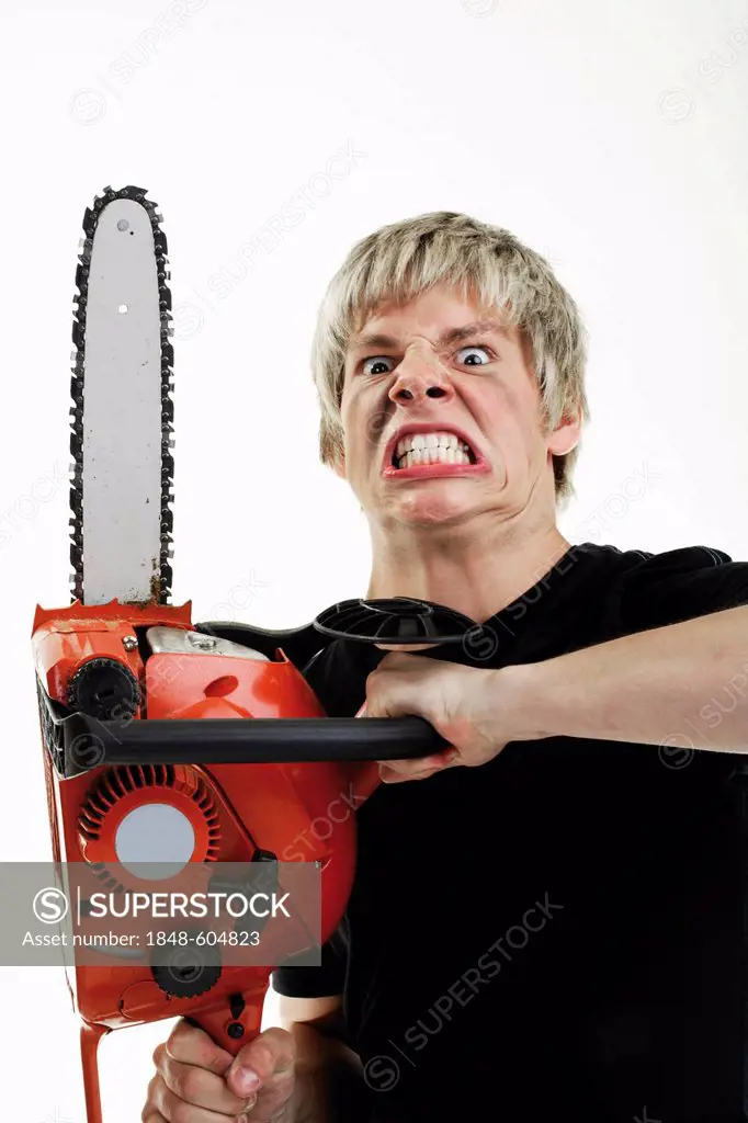 Young man with angry expression handling a chainsaw