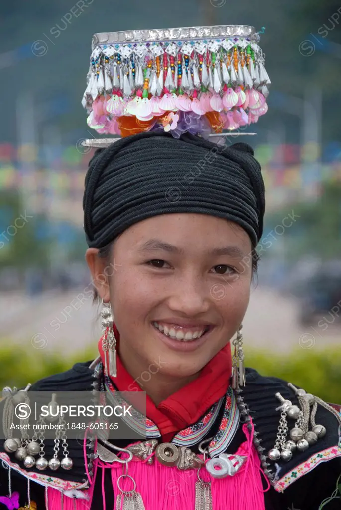 Ethnic festival, portrait, young woman of the Yao minority in traditional costume with headdress smiling, Jiangcheng, Pu'er City, Yunnan Province, Peo...