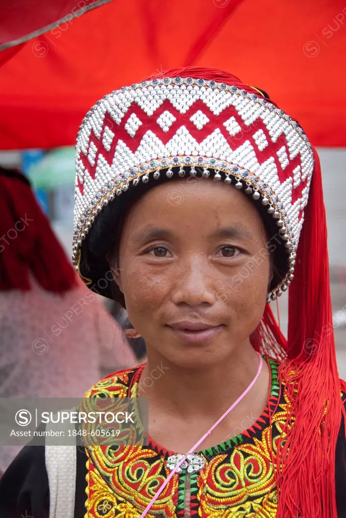 Woman of the Yi or Hani ethnic minority wearing colourful headware at a festival, portrait, Jiangcheng, Pu'er City, Yunnan Province, People's Republic...