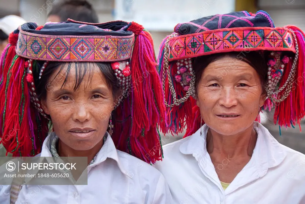 Two women of the Yi or Hani ethnic minority wearing colourful headware at a festival, portrait, Jiangcheng, Pu'er City, Yunnan Province, People's Repu...