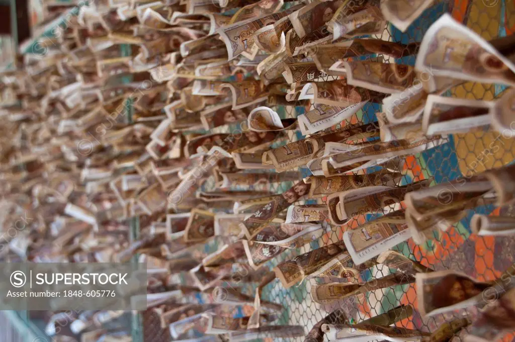 Money donated by pilgrims on a fence in Gyantse, Tibet, Asia