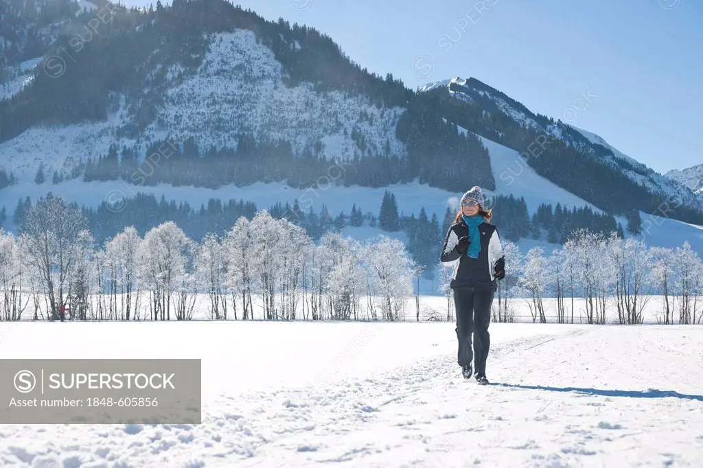 Woman jogging in the snow in the mountains