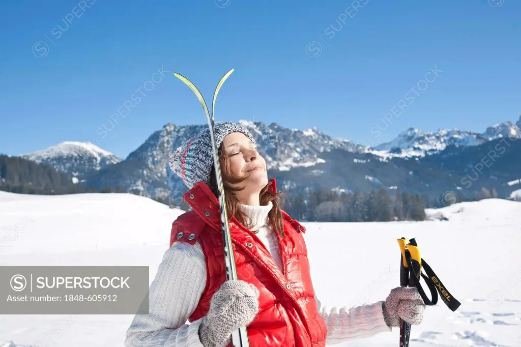 Woman with cross-country skis in the mountains