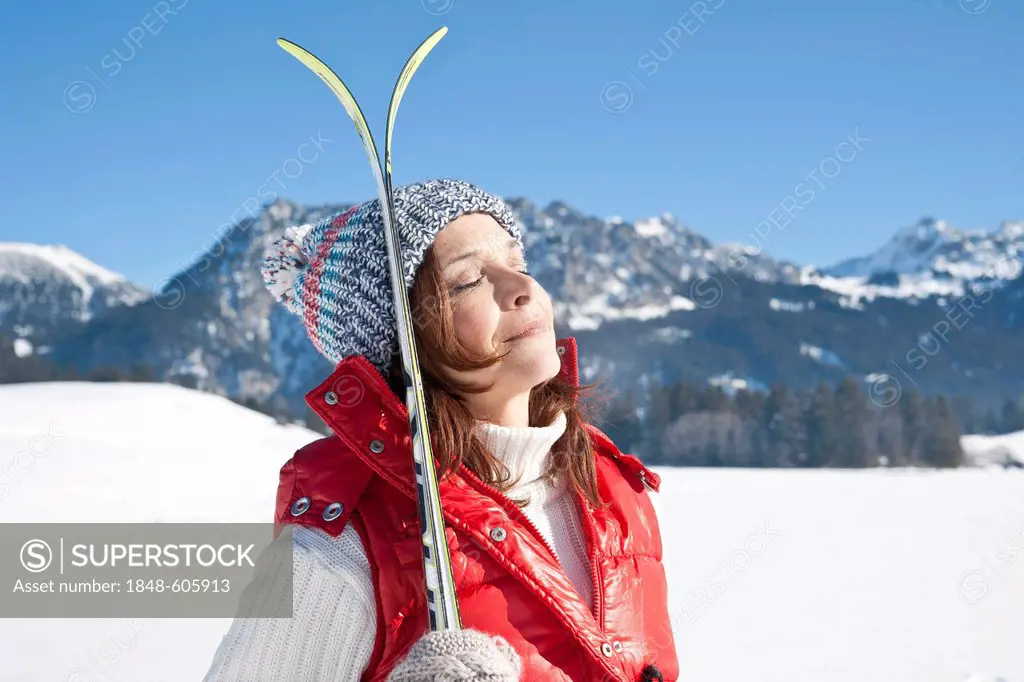 Woman with cross-country skis in the mountains