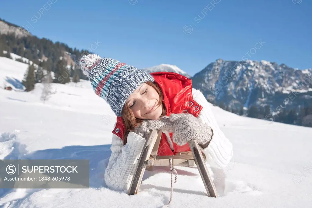 Woman on a sled in the mountains