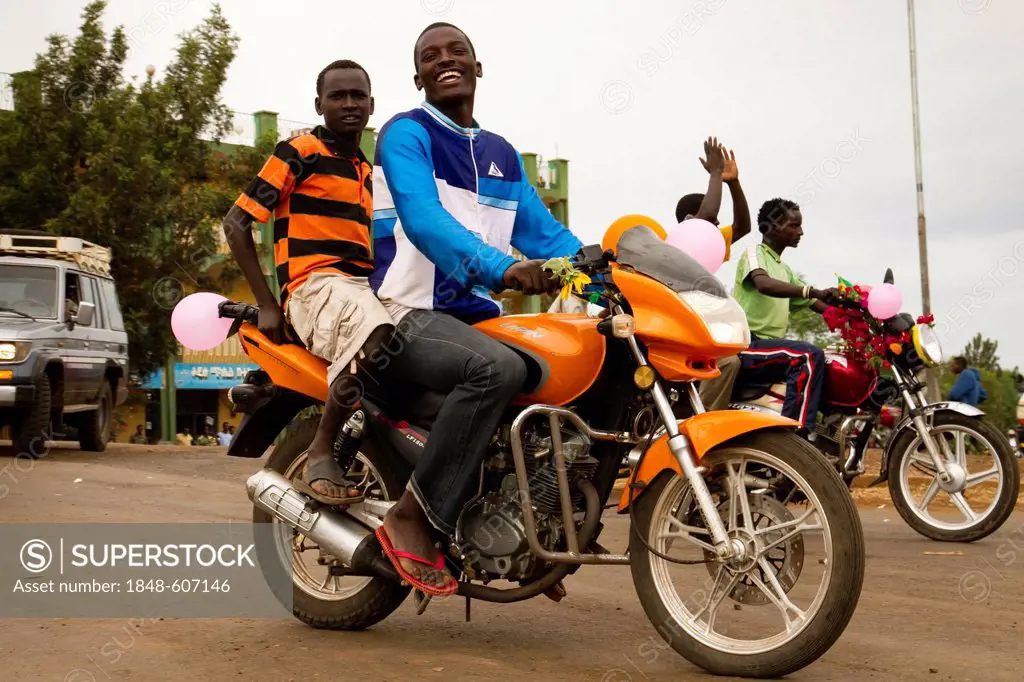 Young men, honking motor-bikes for wedding party, Karat-Konso, Omo Valley, South Ethiopia, Africa