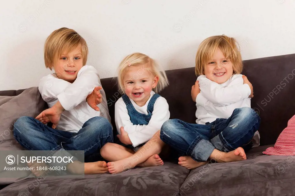 2 boys, 7 and 4 years, and a girl, 1.5 years sitting cross-legged