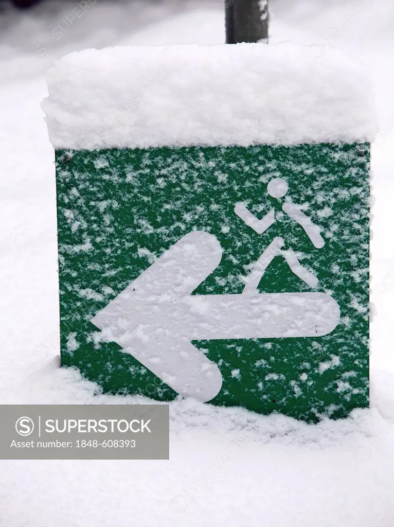 Snow-covered sign on a jogging path in Gruga Park, Essen, North Rhine-Westphalia, Germany, Europe