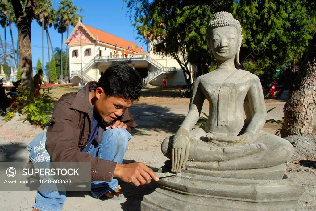Theravada Buddhism, stonemason, working on a delicate detail, fingers, hands of a Buddha statue, Wat Xayaphoum temple, Savannakhet, Laos, Southeast As...