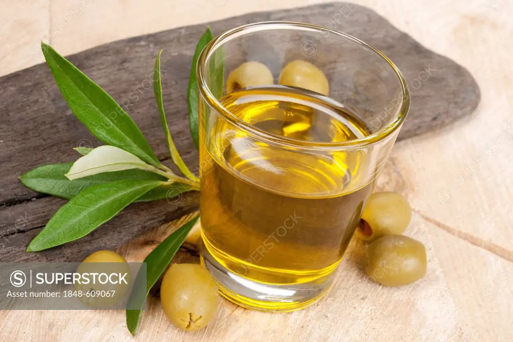 Glass with olive oil and olives