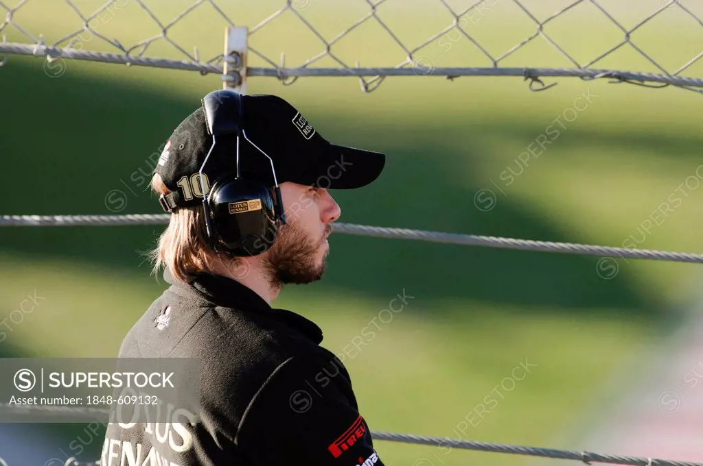 Portrait of Nick Heidfeld, ENG, Lotus Renault GP, observing events through a fence, Formula 1 testing at the Circuit de Catalunya race track near Barc...