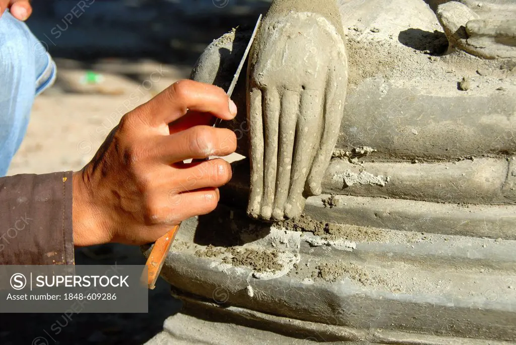Theravada Buddhism, stonemason, working on a delicate detail, hand of a Buddha statue, Wat Xayaphoum temple, Savannakhet, Laos, Southeast Asia, Asia
