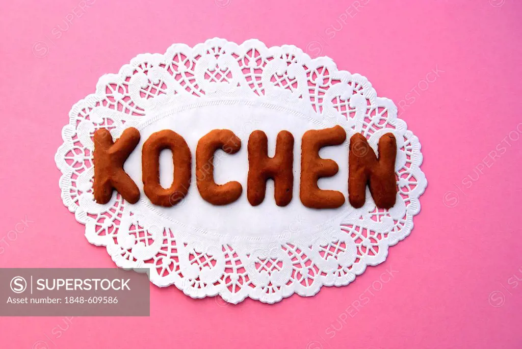 Lettering Kochen, German for cooking, alphabet biscuits on a cake lace coaster