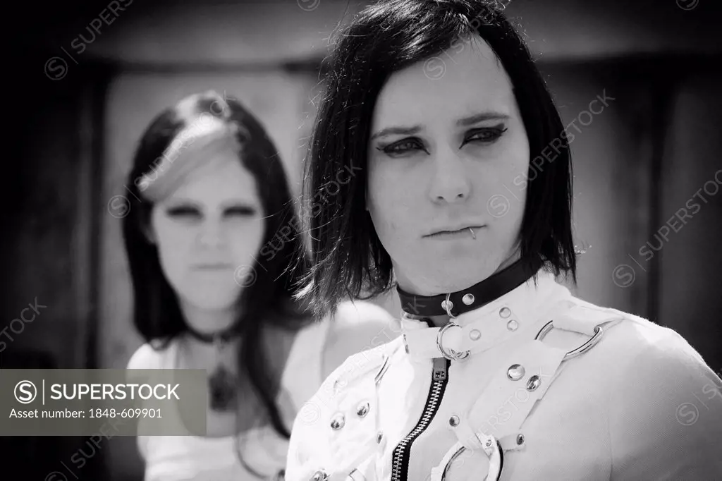 Pair, musicians dressed in a Goth style, Retro, with a serious look on their faces
