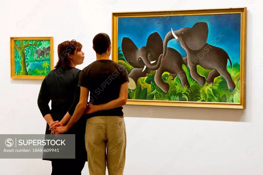 Two young people looking at fine art paintings