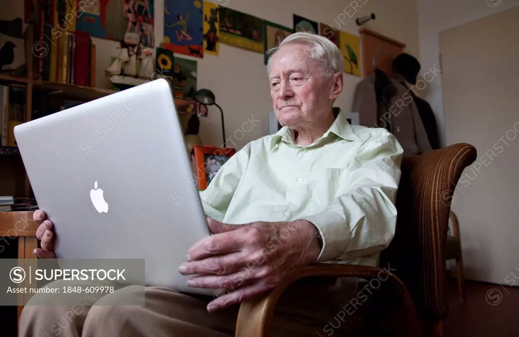 Elderly man, senior citizen holding an Apple Macintosh laptop computer on his knees, nursing home, retirement home, Berlin, Germany, Europe