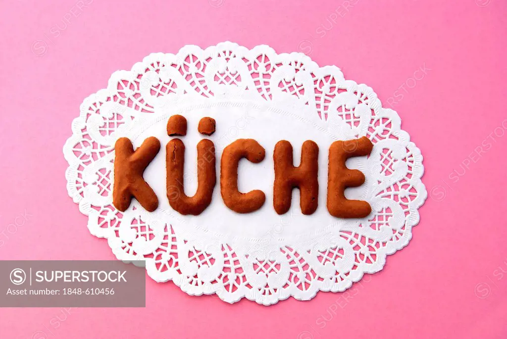 Lettering Kueche, German for kitchen, alphabet biscuits on a cake lace coaster