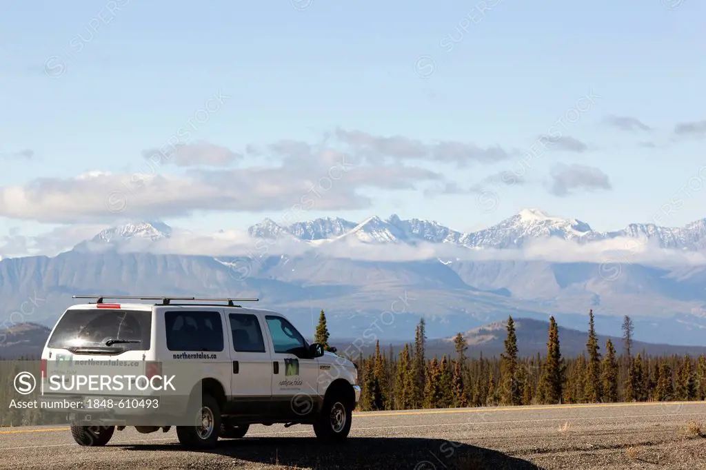 SUV on Alaska Highway, north of Whitehorse, St. Elias Mountains, Kluane National Park and Reserve behind, Yukon Territory, Canada