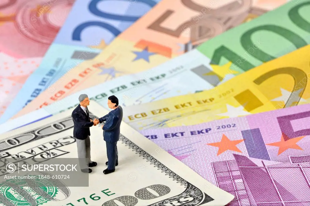 Manager figures on U.S. dollars and euros, symbolic image for business, business men, sealing a contract, foreign currency