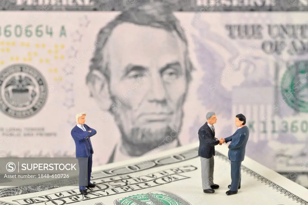 Manager figures on U.S. dollars, symbolic image for business, business men, sealing a contract
