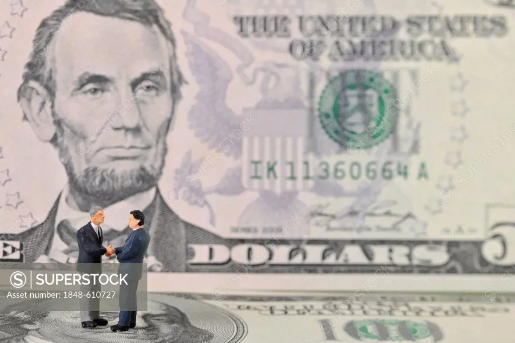 Manager figures on U.S. dollars, symbolic image for business, business men, sealing a contract