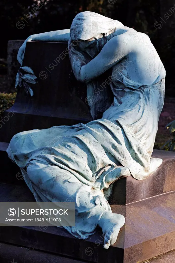 Sculpture of a grieving woman sitting on a grave stone, historic grave sculpture, Nordfriedhof Cemetery, Duesseldorf, North Rhine-Westphalia, Germany,...