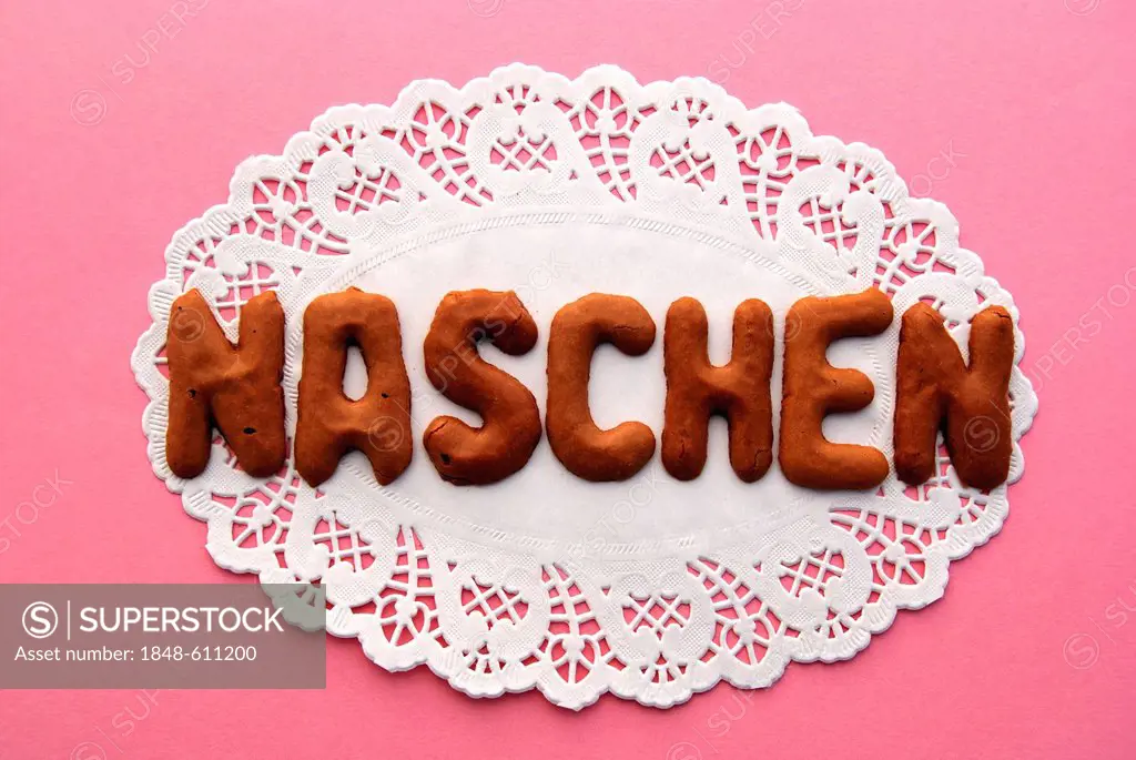 Lettering Naschen, German for eating sweets, lettering, alphabet biscuits on a cake lace coaster