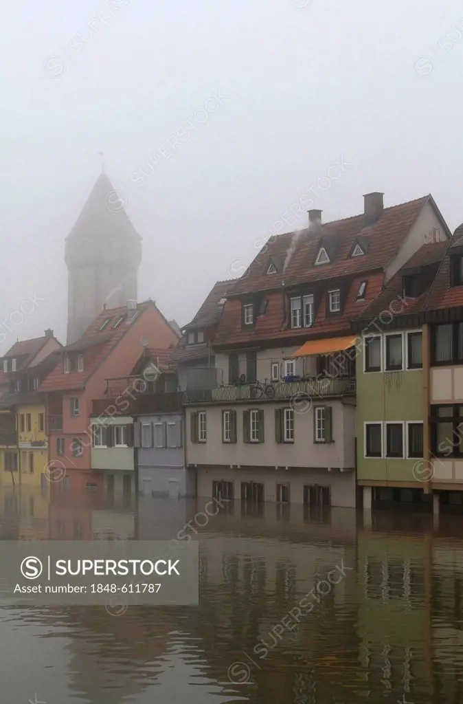 Floodwaters and fog, buildings on the bank of the Tauber river, seen from the Tauber river bridge on Bahnhofstrasse street from direction of Main estu...